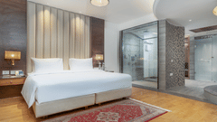 A bedroom in our Suite with  a large bed, soft lighting and cosy decor - Sarovar Premiere, Srinagar